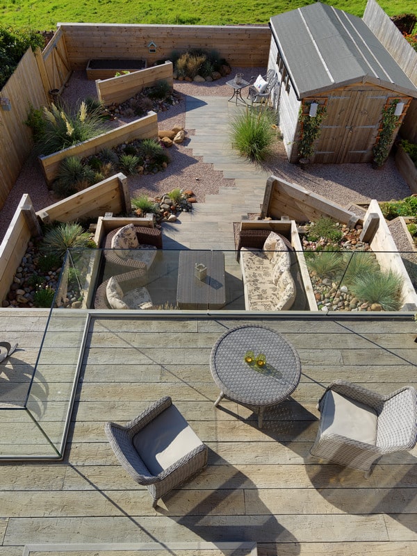 Working to a theme. Sea groynes and drift wood style decking and paving in a costal themed garden